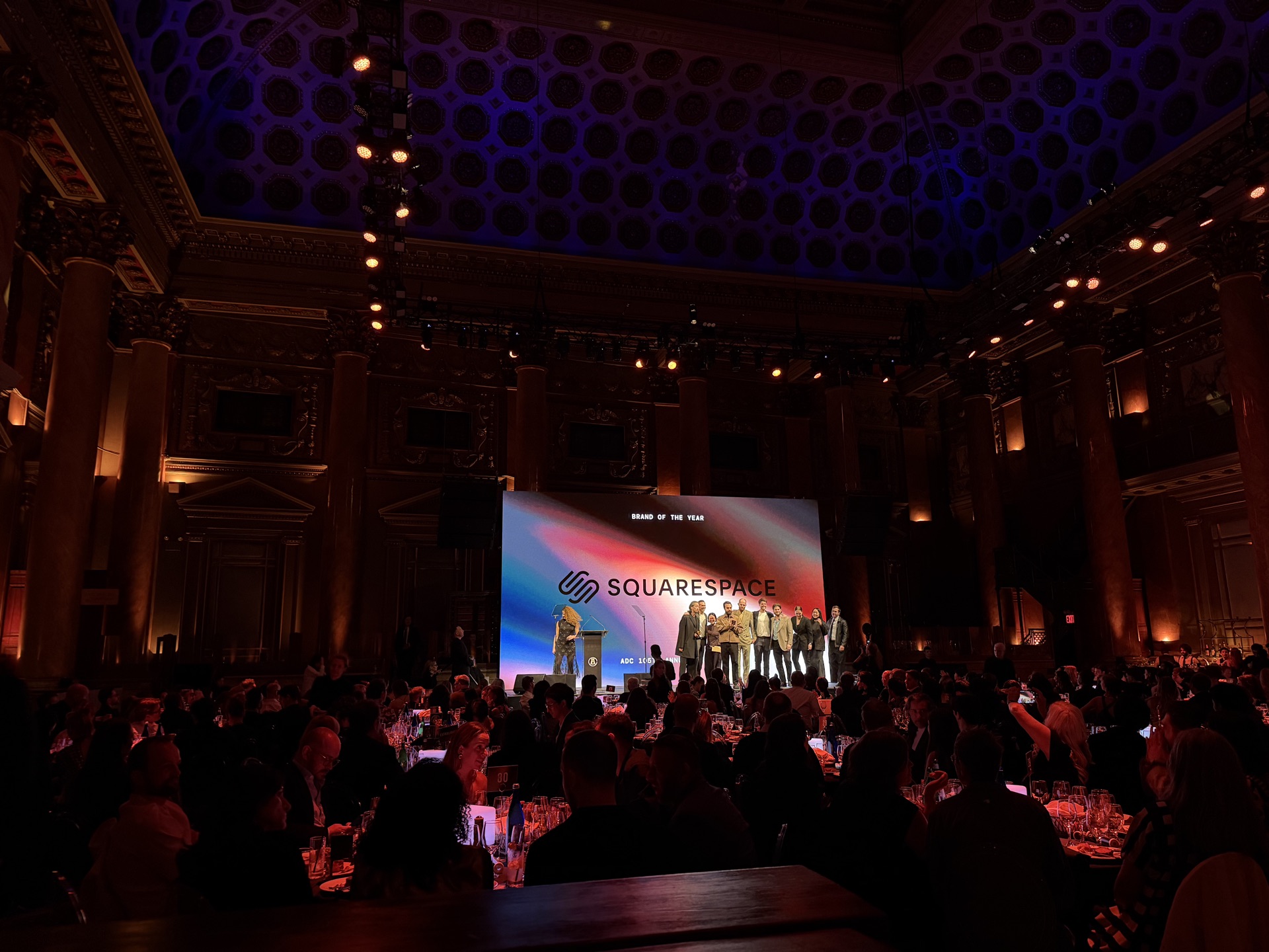 ADC Awards ceremony LED wall showing brand content, packed crowd